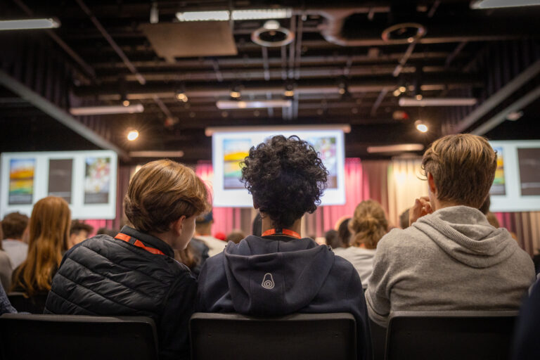 Studenter som tittar på presentation i en sal